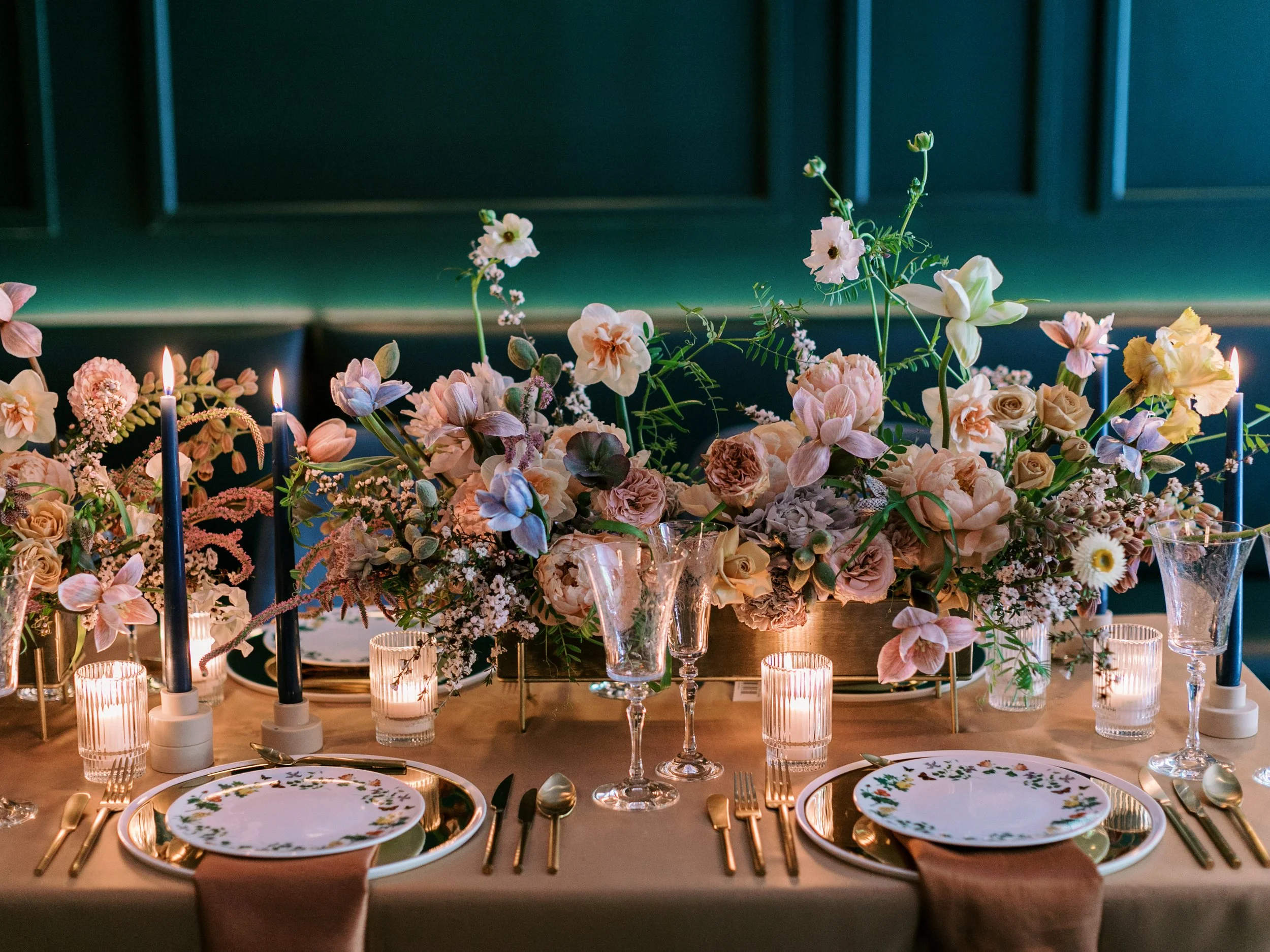 Mesa con arreglos florales en tonos suaves y velas